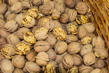Freshly harvested walnuts in a wicker basket displayed at a local autumn market showcasing natural organic produce
