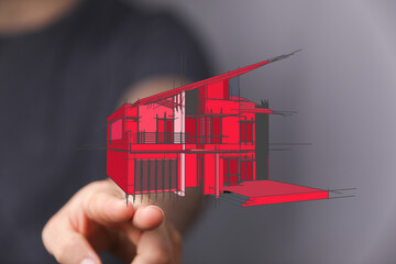 Digitally drawn red house sketch held by hand, representing architecture, design, and real estate...
