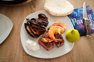 Surf n Turf am Teller mit Tzatziki, F&auml;cheraubergine, Pitabrot und Zitronenh&auml;lfte
