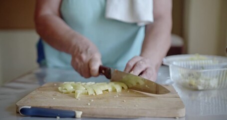 Expert hands meticulously slice a vibrant green bell pepper on a rustic wooden cutting board. - Powered by Adobe