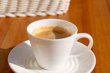 Warm cup of coffee on a wooden table in a cozy cafe setting