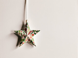 Decorative paper star ornament hanging on a white background
