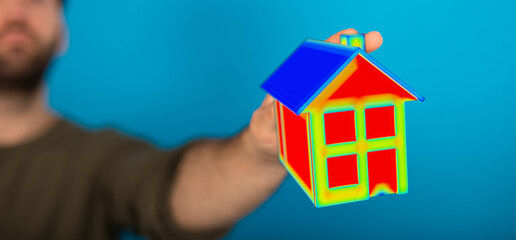 A person holding a model house with energy-efficient features, emphasizing sustainability and eco-friendly living. Ideal for representing enviro