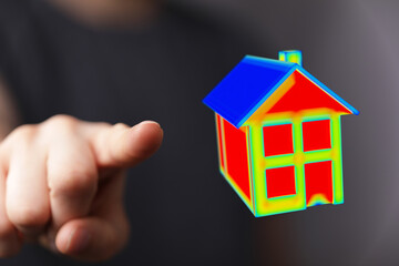 A person's hand points towards a vibrant, conceptual house, symbolizing real estate, property, and homeownership. Focus on the modern design and