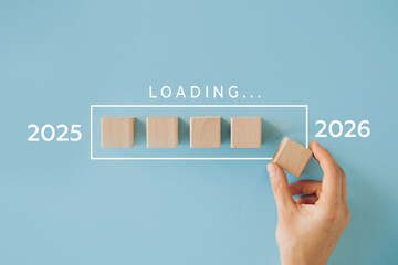 Transition from 2025 to 2026 loading concept with wooden cubes. Represents time passing, preparation for the new year, planning, and progress