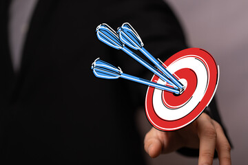 Businessman hand pointing to a target with darts, success, achievement concept, goal setting, aim, strategy, business and victory. Perfect for f