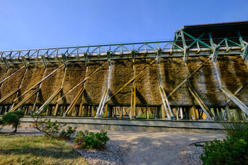 Large wooden graduation tower surrounded by green shrubs