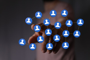 Hand touching network of people icons, representing social connection, communication and global...