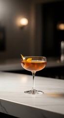 A cocktail glass with orange peel garnish stands alone on a light marble bar top. Elegant alcoholic drink for bar menu and evening gathering.