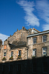 Edinburgh Castle hinter historischen Wohnh&auml;usern bei Sonnenschein