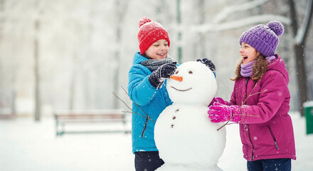 Two children building snowman together in winter park with snow  