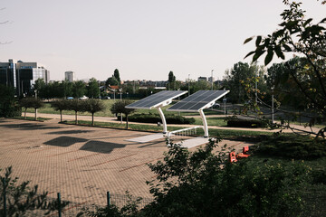 Contemporary solar charging structure for electric vehicles in a green city park with urban background