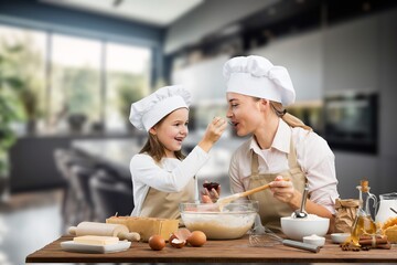 The beautiful young mother and her little daughter cooking