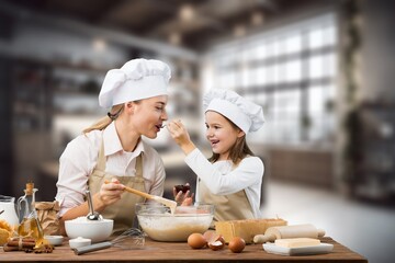 The beautiful young mother and her little daughter cooking