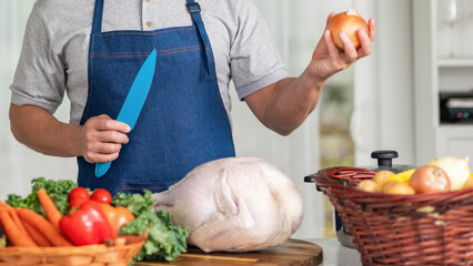 Thanksgiving day dinner. Chef man cooking in kitchen. Thanksgiving dinner food. Man cooking food. Cooking turkey for Thanksgiving. Man in apron with turkey. Home menu. Thanksgiving centerpiece