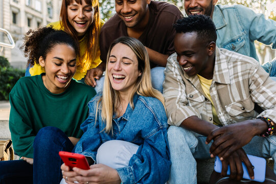 Multiracial young people having fun watching social media content on phone. Technology lifestyle and social media concept