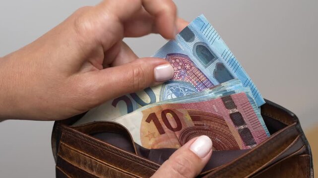 Unrecognizable woman counting euros in her wallet or purse. Counting  bills close-up.