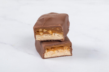 Chocolate Candy bar with nougat and caramel, peanuts and hazelnuts. Close up. White background