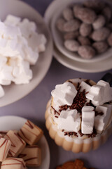 gourmet dessert arrangement featuring whipped cream-topped hot chocolate with marshmallows and assorted sweets in a cozy setting, attractive, tempting, appetizing, arrangement, visual, sprinkles