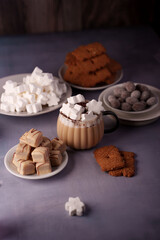 cozy arrangement of hot cocoa with marshmallows and assorted cookies on textured surface evoking warmth and comfort in a soft, muted palette, flavorful, culinary, lifestyle, presentation, baking
