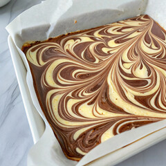 Swirling marbled chocolate and vanilla melted on parchment paper	