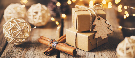 Christmas gifts wrapped in brown paper with cinnamon sticks and string lights for holiday celebrations