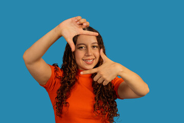 Young woman framing face with hands creating vision
