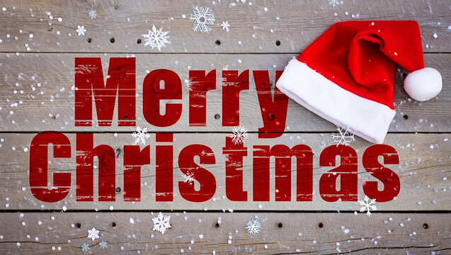 Festive red text and Santa hat on wooden background with snowflakes christmas white