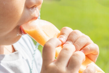 アイスを食べている男の子の口元（日本人、2歳、屋外）