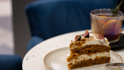 Carrot Cake Slice with Figs on a Plate in Cozy Cafe