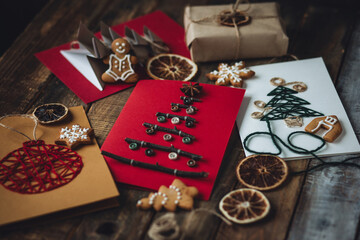 Traditional Christmas handmade crafted postcard, gingerbread cookies. Wooden background. Festive mood, cozy home atmosphere. Family time, holiday leisure. Natural recyclable materials, zero waste
