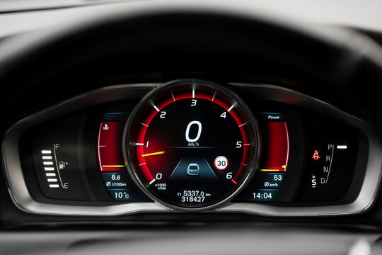 Modern digital car dashboard with illuminated speedometer and electronic display showing fuel level, temperature, and drive mode indicators in high-resolution interface