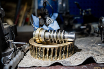 Metal worm gear and threaded shaft on workbench representing industrial mechanics, engineering...
