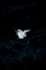 Naklejka premium Open pill capsule and white powder in dark studio shot surrounded by pills . Concept with medicine and substance abuse and addiction. with negative space and .copy space