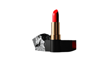 A red lipstick stands, contrasting against black background, with a crumpled silver foil accent on one side