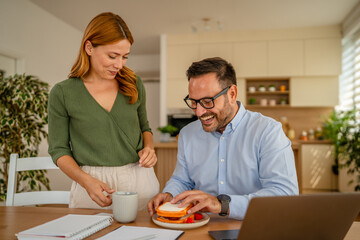 Couple enjoying breakfast together while working from home