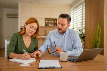 Obraz premium Couple calculating expenses together in home office