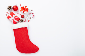 Christmas sock with gifts and decoration on color background, top view