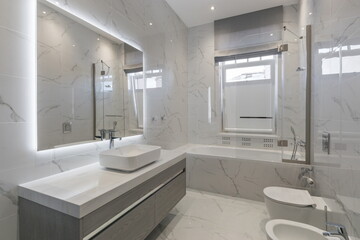Modern bathroom design featuring marble tiles and sleek fixtures in a bright, spacious setting