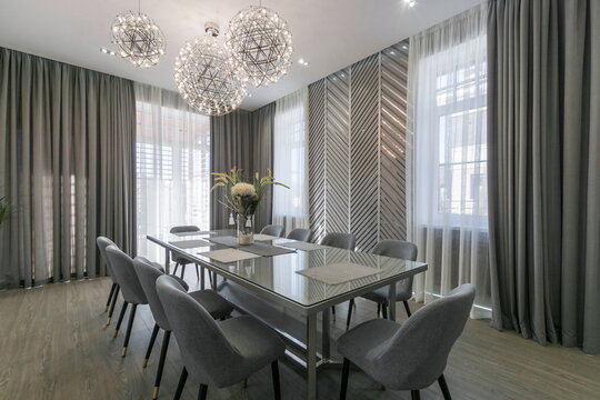 Modern dining room with elegant lighting and stylish decor in a spacious setting featuring gray tones and natural light