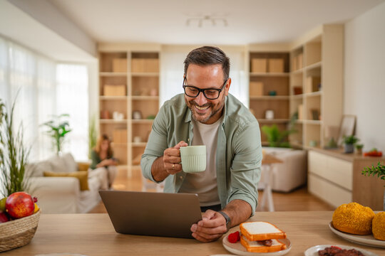Man working from laptop while having breakfast