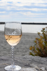 Close-up of a glass of rose wine. Engraved crystal glass. The Mediterranean Sea in background. In Camargue.