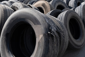Pile of used car tires ready for recycling. Stacked old tires in a recycling yard. Old worn-out tires piled together outdoors. © onderortel