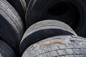 Pile of used car tires ready for recycling. Stacked old tires in a recycling yard. Old worn-out...