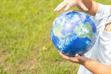 地球儀を持って草原で立っている男の子（2歳、日本人、顔無し）
