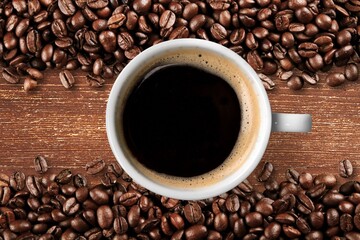 A cup of dark aroma roasted coffee on wooden surface