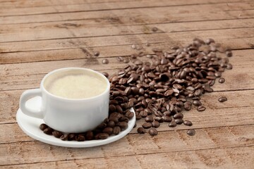 A cup of dark aroma roasted coffee on wooden surface