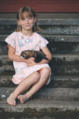 Nice young lady posing on stairs with her lovely ferret friend