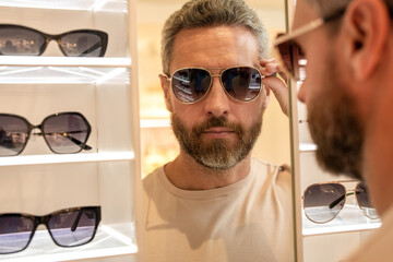 Eyewear collection. Fashion look with sunglasses. Man choosing sunglasses in shop. Sunglasses model in fashion store. Fashionable man. Trendy sunglasses accessories for men. Fashion portrait