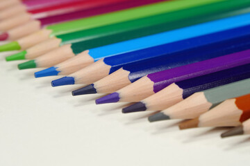 Fototapeta premium New wooden colored pencils of rainbow colors, perfectly sharpened, lie on table